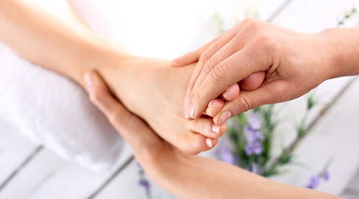 Therapist providing a foot reflexology treatment